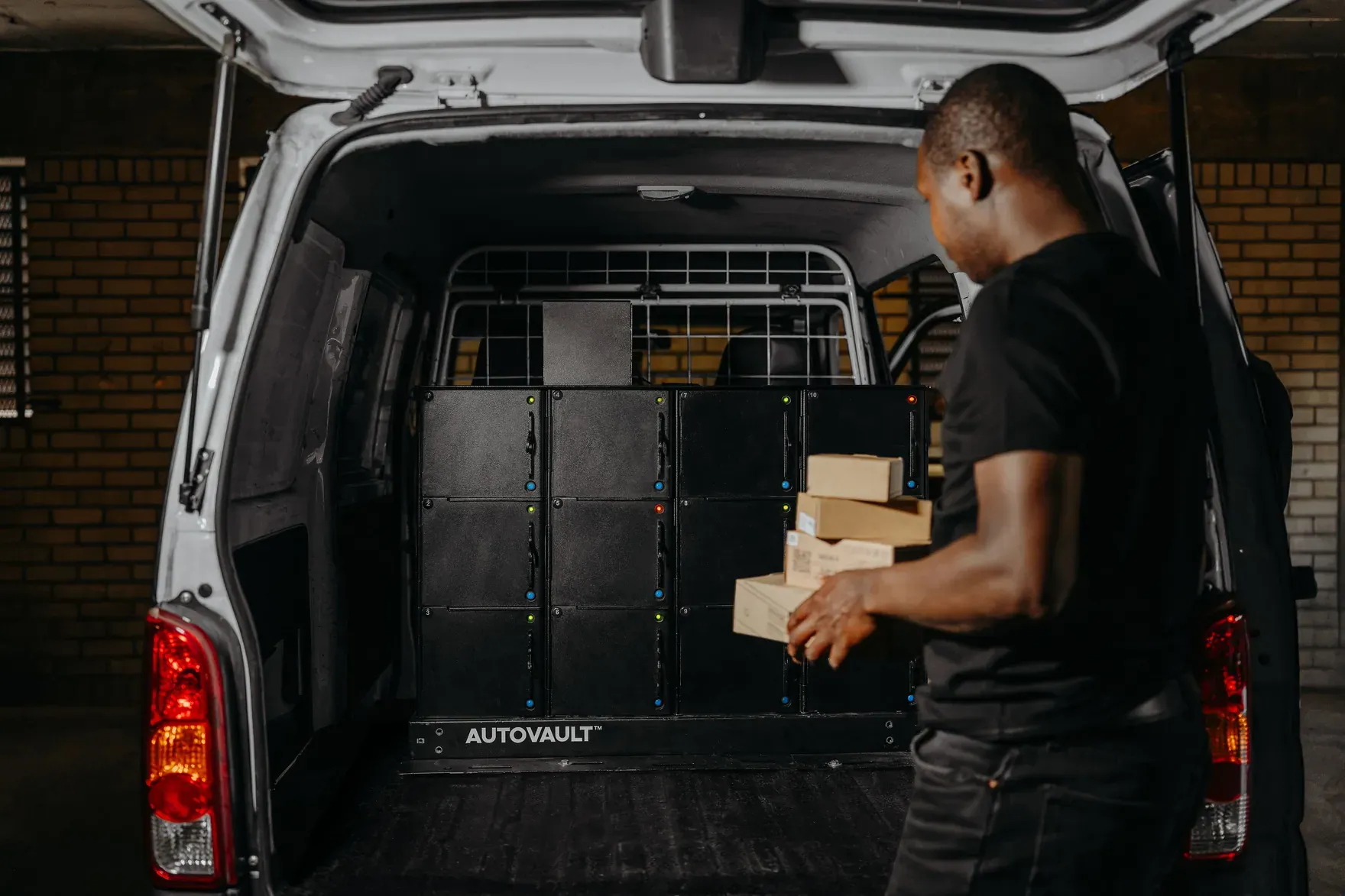 A courier loading parcels into the AutoVault in his van