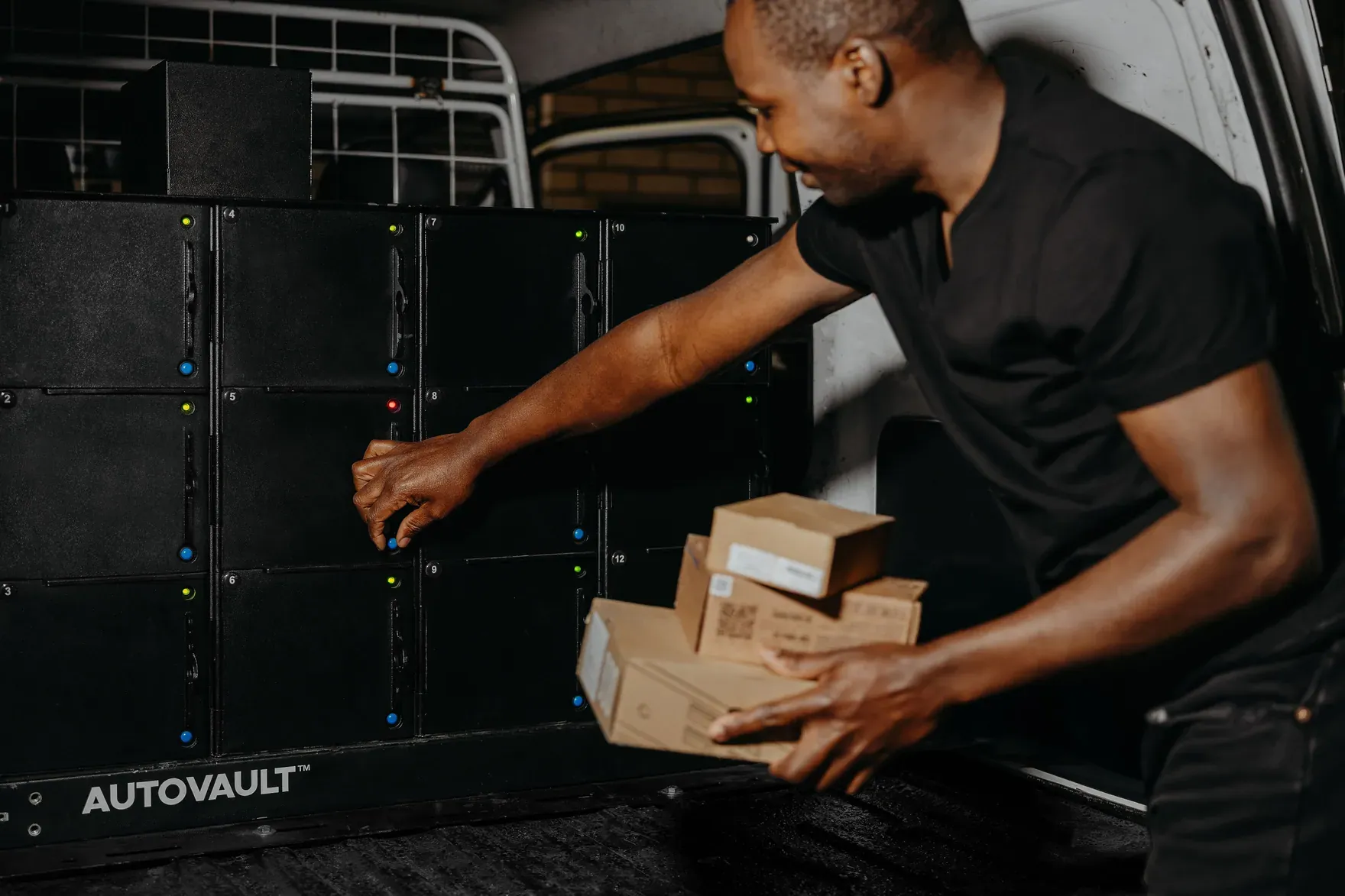A courier opening an AutoVault compartment to load a parcel