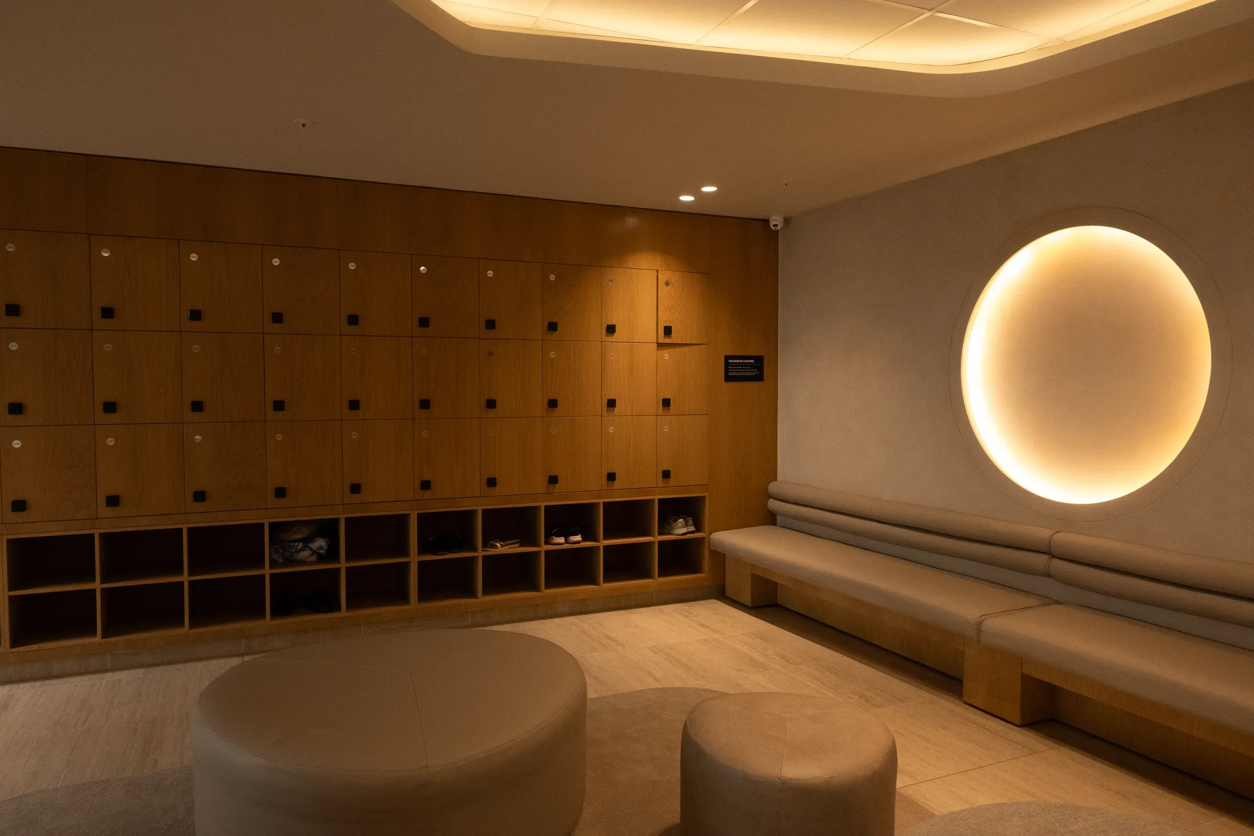 A gym change room with timber lockers, an open storage wall and benches