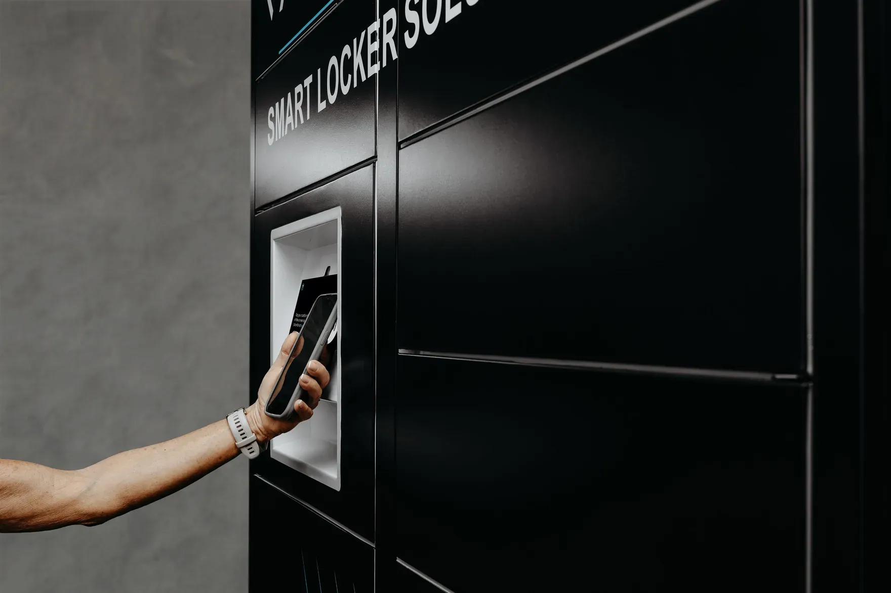 A guest tapping a phone to pay on a PackVault screen